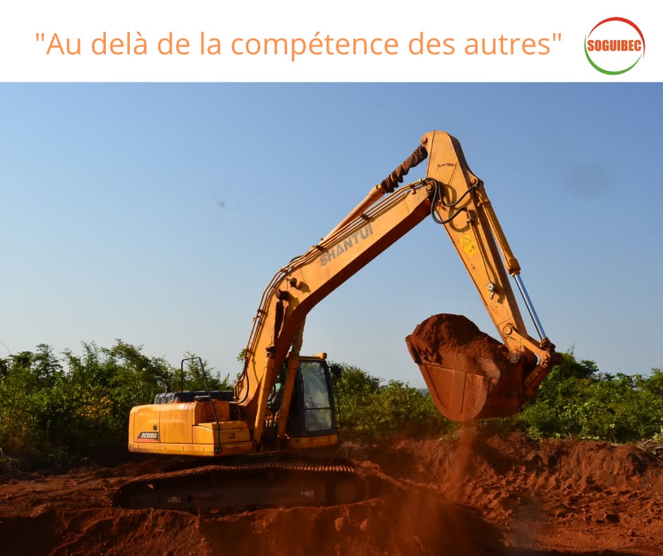 Excavatrice Shantui de la SOGUIBEC, godet chargé de latérite, sur un chantier de terrassement