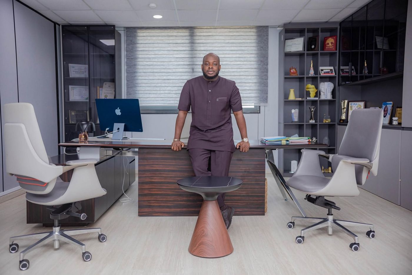 Bakary DIABY, Président-Directeur Général, debout dans son bureau de direction, devant un grand bureau, trophées et certificats en arrière-plan